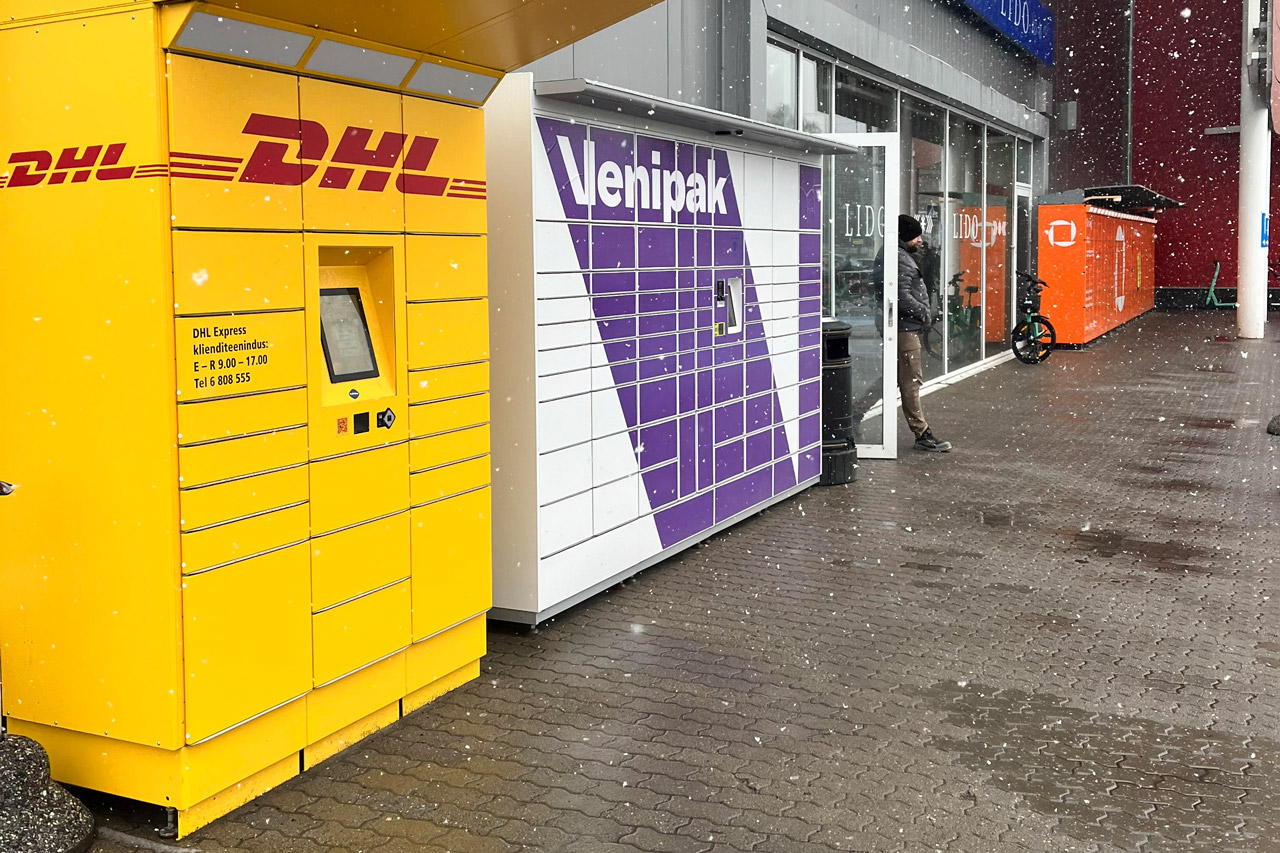 Kolme eri firma pakiautomaadid kaupluse sissepääsu kummalgi küljel.
